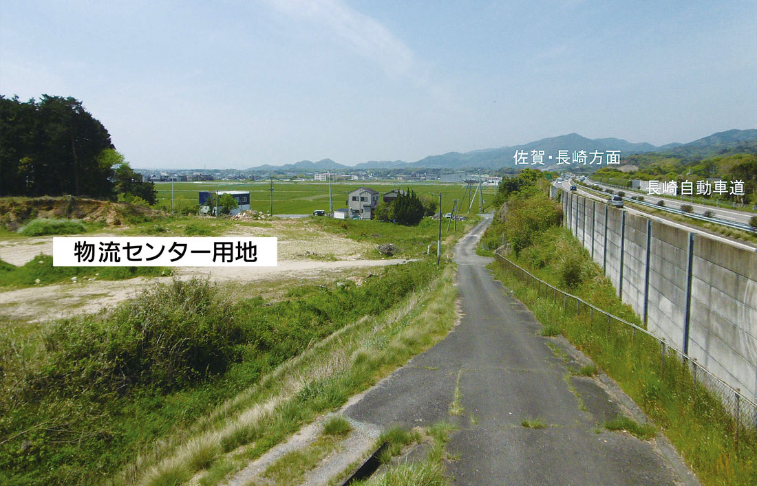 北側、長崎自動車道横の道路から事業用地を望む